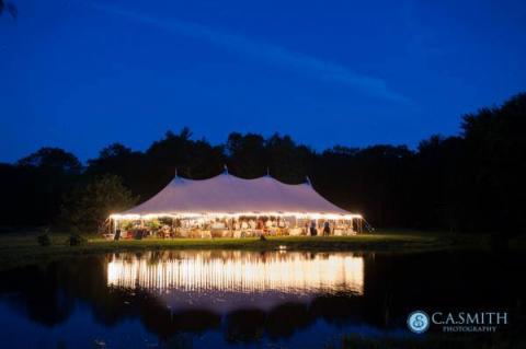 Wedding tent at night across pond